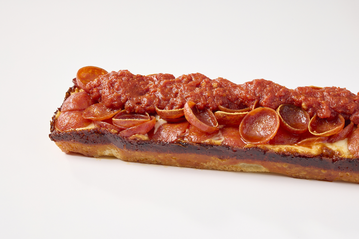 Real pepperoni EDGE pizza with caramelized cheese crust and sauce across the top